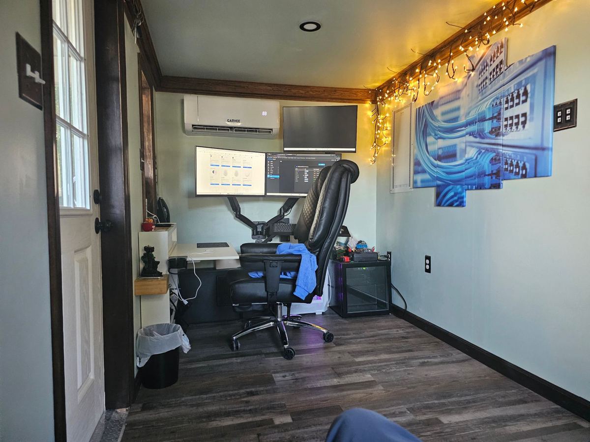 Effitech office in Pittsville with three monitors on arms, desk and network-themed wall art